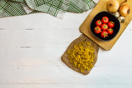 Pasta ingredients isolated. Cherry tomato, pasta, garlic and onions