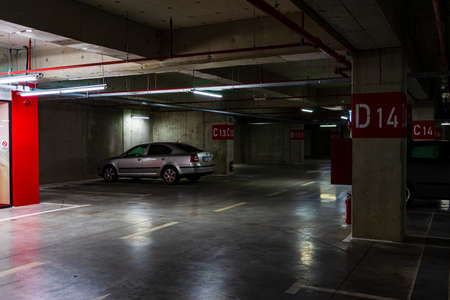 Parking garage interior with a few parked cars. Underground parking garage in Bucharest, Romania, 2021のeditorial素材