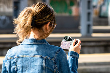 Young woman taking photos at railstation in Bucharest, Romania, 2022