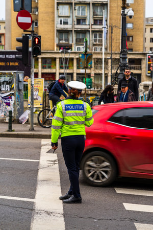 Police agent, Romanian Traffic Police (Politia Rutiera) directing traffic during  rush hour in...