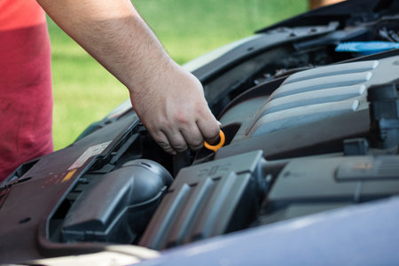 Car mechanic checking the engine oil level