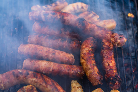 Grilling sausages on barbecue grill. Delicious sausages on charcoal grill