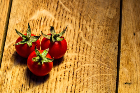 Fresh cherry tomatoes on rustic wooden backgroundの写真素材