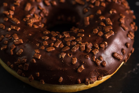 Chocolate glazed donut with chocolate chips isolated. Close up of delicious donut.の写真素材