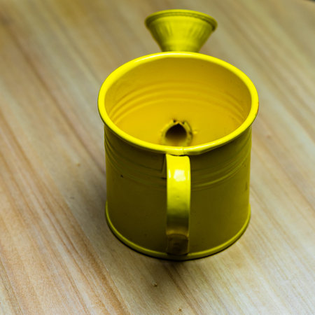 Yellow watering can on wooden tableの写真素材