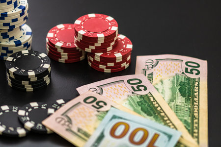 Stacks of poker chips and dollar bills on black background. Poker concept, chips and money.