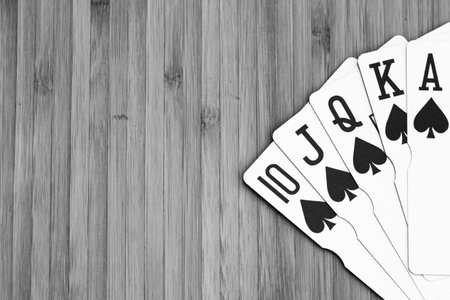 Playing cards royal flush close up, isolated on wooden table. Casino concept, risk, chance, good...