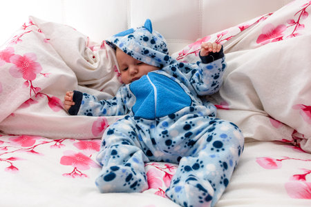 Sleeping newborn baby boy in bed. Newborn baby