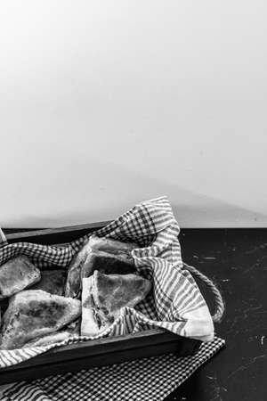 Freshly baked homemade ham and cheese puff pastry in a rustic crateの写真素材