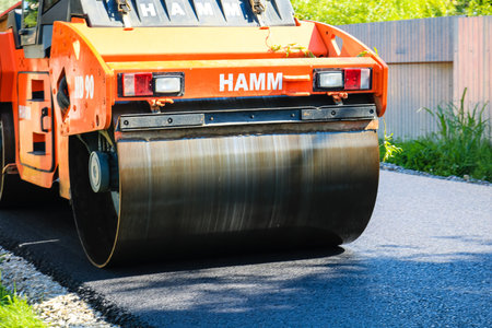 Workers and asphalting machines. Construction, asphalting of new road in Bucharest, Romania, 2022