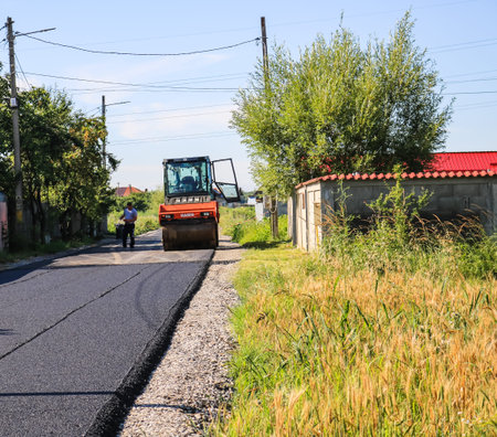 Workers and asphalting machines. Construction, asphalting of new road in Bucharest, Romania, 2022