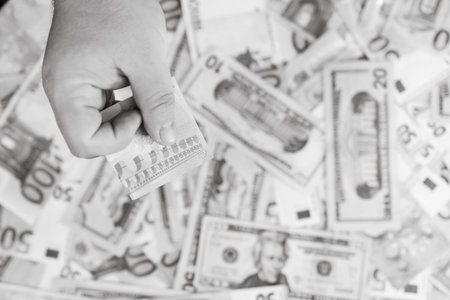 Hand giving money like bribe or tips isolated on banknotes background. EURO and USD currency...