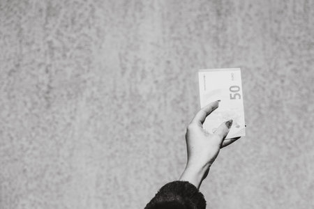 Hand holding showing euro money and giving or receiving money like tips, salary. 50 EURO banknotes...