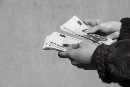 Hand holding and showing euro money or giving money. World money concept, 100 EURO banknotes EUR currency isolated. Concept of rich business people, saving or spending money.の写真素材
