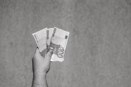 Hand holding and showing euro money or giving money. World money concept, 100 EURO banknotes EUR currency isolated. Concept of rich business people, saving or spending money.の写真素材