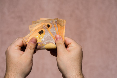 Hand couting holding and showing euro money or giving money. World money concept, 50 EURO banknotes...