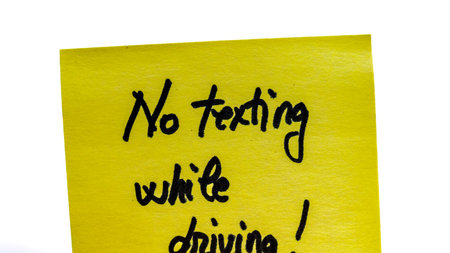 No texting while driving handwriting text close up isolated on yellow paper with copy space.の写真素材