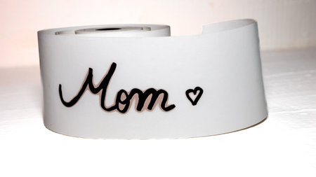 Mom writing love text for mother on paper. Label tag with lovely message for mother`s day.の写真素材