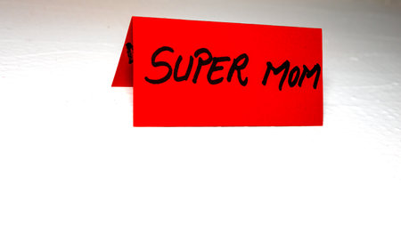 Super mom writing love text for mother on paper. Label tag with lovely message for mother`s day.の写真素材