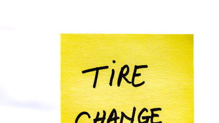 Tire change handwriting text close up isolated on yellow paper with copy space.の写真素材