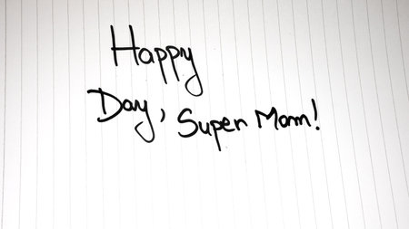 Happy day super mom writing love text for mother on paper. Label tag with lovely message for mother`s day.の写真素材