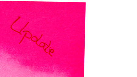 Update handwriting text close up isolated on pink paper with copy space. Writing text on memo post reminderの写真素材