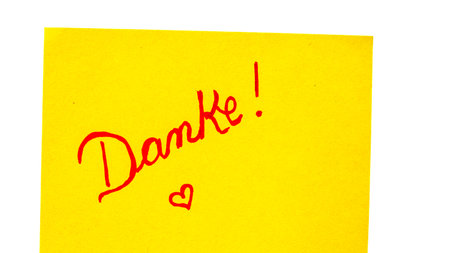 Donate handwriting text close up isolated on orange paper with copy space. Writing text on memo post reminderの写真素材
