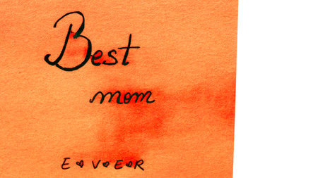 Best mom ever handwriting text close up isolated on orange paper with copy space. Writing text on memo post reminderの写真素材