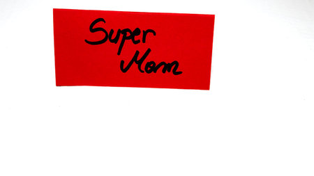 Super mom writing love text for mother on paper. Label tag with lovely message for mother`s day.の写真素材