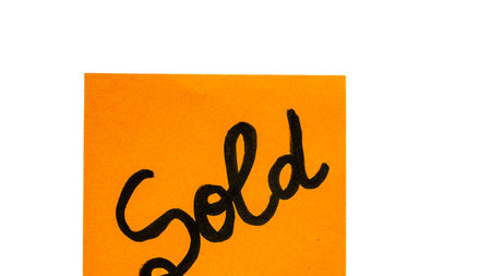 Sold handwriting text close up isolated on orange paper with copy space.の写真素材