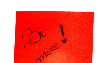 Be mine handwriting text close up isolated on orange paper with copy space. Writing text on memo post reminderの写真素材