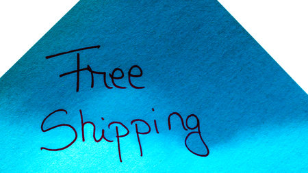 Free shipping handwriting text close up isolated on blue paper with copy space. Writing text on memo post reminderの写真素材