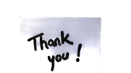 Thank you handwriting text close up isolated on white paper with copy space. Writing text on memo post reminderの写真素材