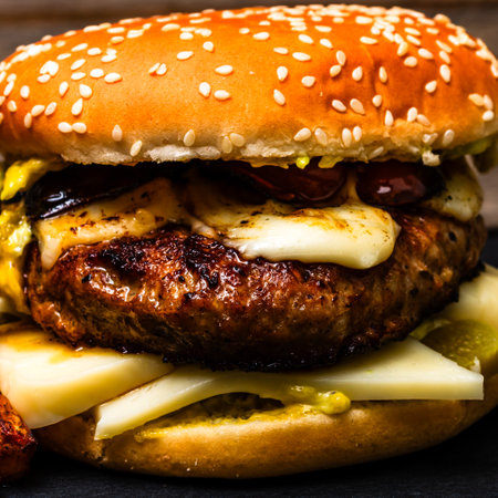 Tasty home made cheeseburger. Cheese burger with pickles, tomatoes, onion, melting cheeseの写真素材