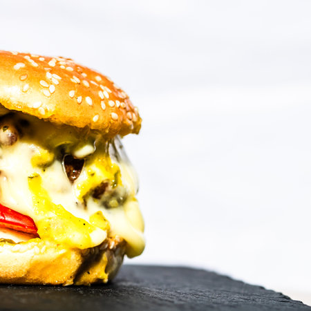 Tasty home made cheeseburger. Cheese burger with pickles, tomatoes, onion, melting cheeseの写真素材