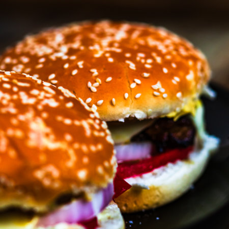 Tasty home made cheeseburger. Cheese burger with pickles, tomatoes, onion, melting cheeseの写真素材
