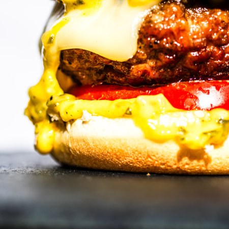 Tasty home made cheeseburger. Cheese burger with pickles, tomatoes, onion, melting cheeseの写真素材