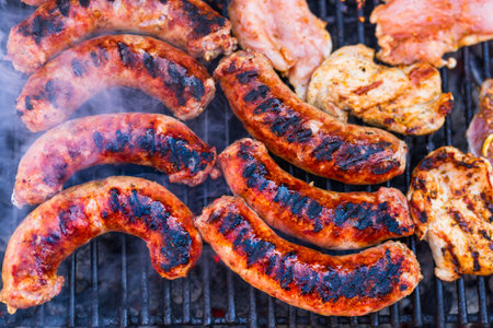 Pork meat and sausages grilled on a charcoal barbeque. Top view of tasty barbecue, food concept, food on grill and detail of food on the grillの写真素材