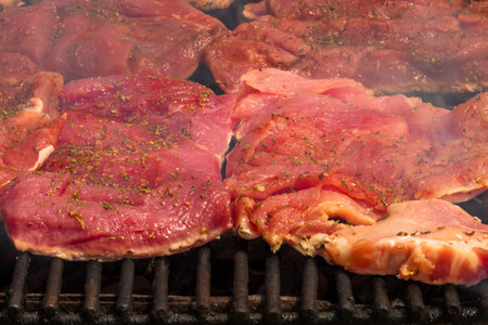 Close up of pork steak grilled on a charcoal barbeque isolated.の写真素材