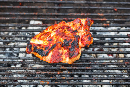 Close up of pork steak grilled on a charcoal barbeque isolated.の写真素材