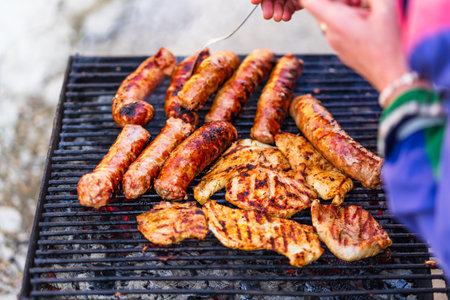 Grilling sausages and pork chops on barbecue grill. BBQ in the garden