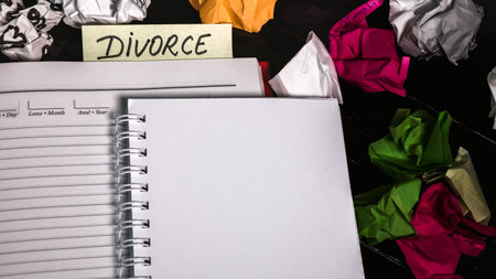 Office desk with agenda, crumpled paper and label with text divorce. Isolated photo