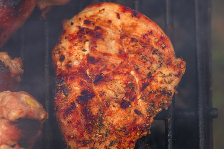 Close up on details of homemade chicken, pork steak and sausages on barbecue grill. Barbecue, grill and food concept.の写真素材