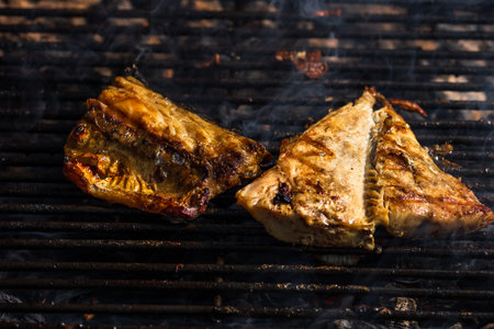 Grilled mackerel fish with smoke on a charcoal barbecue grill.の写真素材