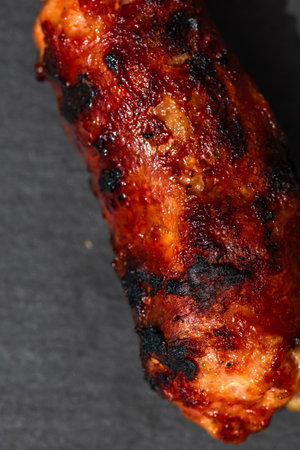 Close up of grilled sausage on small black cutting board isolated. Barbecue, grill and food concept.の写真素材