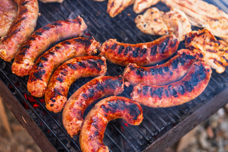 Grilling sausages and pork chops on barbecue grill. BBQ in the gardenの写真素材
