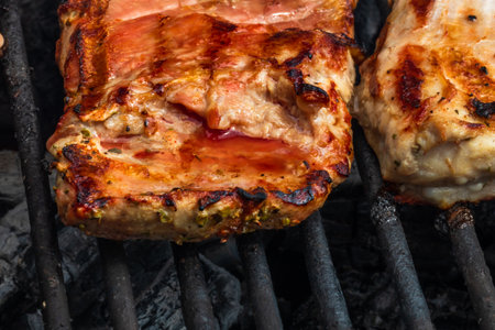 Close up of pork steak grilled on a charcoal barbeque isolated.の写真素材