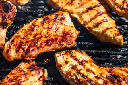Chicken and pork steak grilled on a charcoal barbeque. Top view of camping tasty barbecue, food concept, food on grill and detail of food on the grillの写真素材