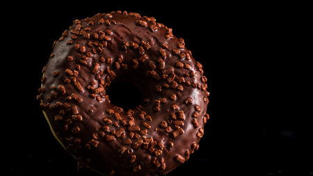 Chocolate glazed donut with chocolate chips isolated. Close up of delicious donut.の写真素材