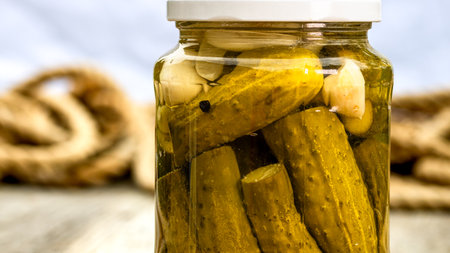 Close up of glass jar with pickles isolated. Preserved food concept, canned vegetables isolated in a rustic composition.の写真素材